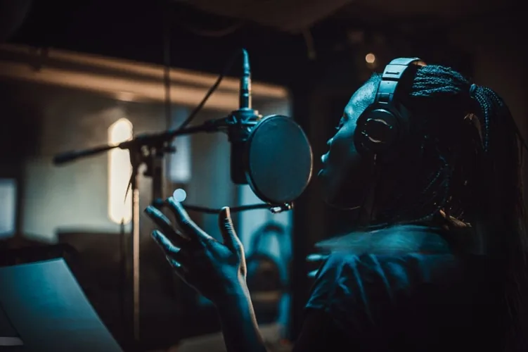 An African artist recording vocals in a home studio